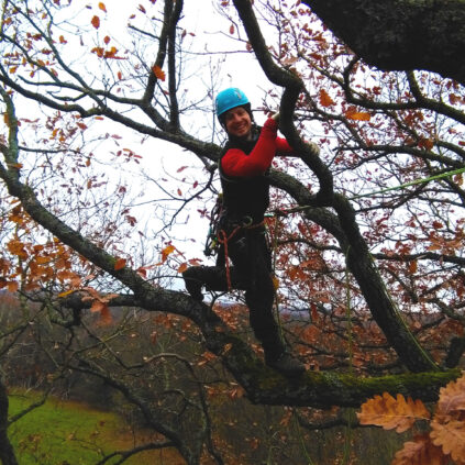 hombre posando feliz agarrado de forma cómica a un árbol